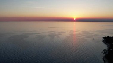 Hırvatistan 'ın Istria kentindeki altın saat batımında, kıyı şeridi, turkuaz sular ve orman manzarasını gösteren Lanterna yarımadasının nefes kesici hava aracı görüntüsü.