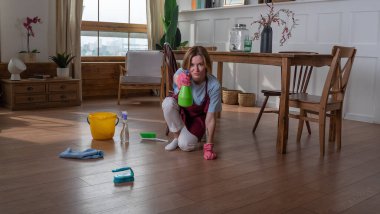 Kafasının yanında sprey şişesi olan kadın odayı temizlemek istemediği için kendini vurmak istiyor gibi görünüyor.