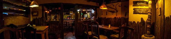 VILLA GESELL,ARGENTINA-MARCH 21,2018:Panoramic of interior of an irish pub. Translation of dark forest in spanish