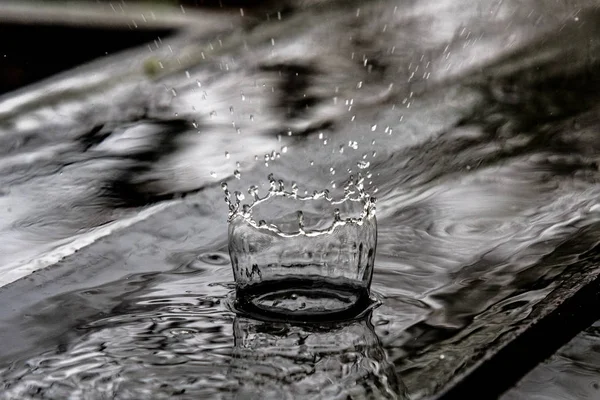 Regn droppe plaska i trägolv studsar och forma en vatten crown — Stockfoto