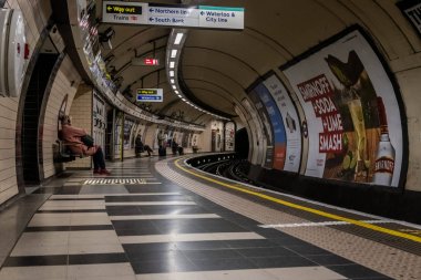 Londra, İngiltere, 10 Aralık 2018: Waterloo metro istasyonunda treni bekleyen ler tabela lar ve reklamlarla dolu.