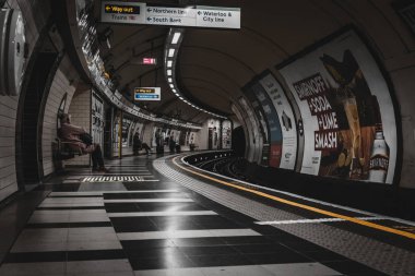 Londra, İngiltere, 10 Aralık 2018: Waterloo metro istasyonunda treni bekleyen ler tabela lar ve reklamlarla dolu.