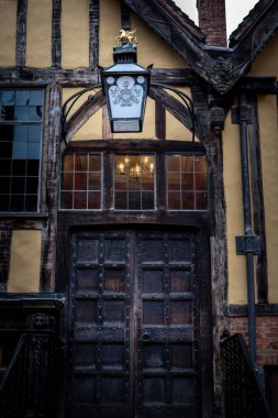 York, İngiltere, 12 Aralık 2018: Yorkshires Merchant Adventurers Hall ahşap kapı eşiğinde ve logosu ve sloganı ile eski fener