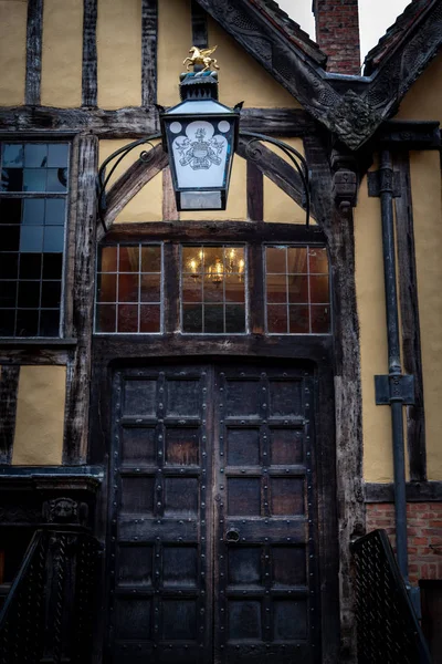 YORK, INGLATERRA, 12 DE DICIEMBRE DE 2018: Yorkshires Merchant Adventurers Hall puerta de madera y linterna vieja con su logotipo y lema — Foto de Stock