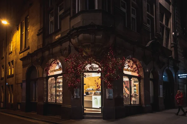 EDINBURGH, SCOTLAND DECEMBER 13, 2018: Beautiful entrance to Charlie Miller hair dresser salon, with a old stylish building and full of flowers and christmas lights. — Stock Photo, Image