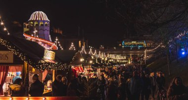 Edinburgh, İskoçya 13 Aralık 2018: Parlak dekorasyon ürünleri yükleri ile ışıklı Noel fuarının panoramik görünümü
