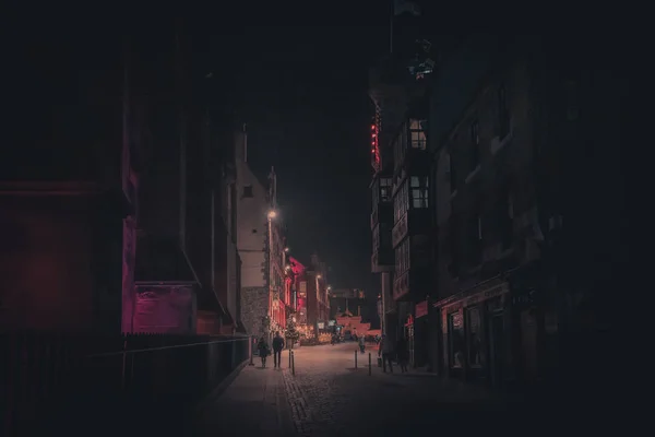 EDINBURGH, SCOTLAND DECEMBER 13, 2018: Romantic scene of couple walking along Victoria St. at night and darkness, illuminated only by far street lights. — Stock Photo, Image