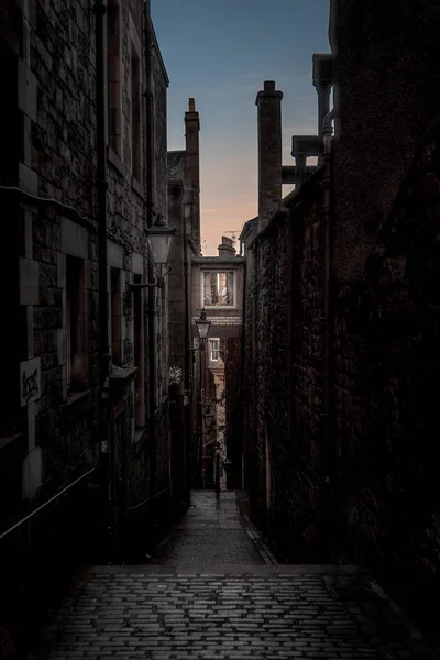 Callejón europeo estrecho, rodeado de ladrillos y adoquines. Iluminado solo con luz débil desde el amanecer. Concepto de miedo o de estar solo y asustado — Foto de Stock