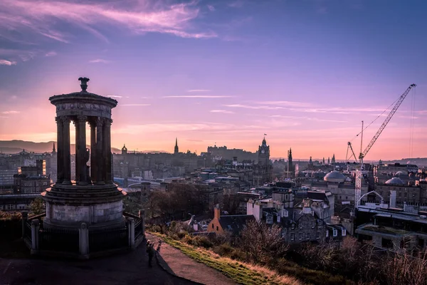 EDINBURGH, SCOTLAND DECEMBER 14, 2018: Beautiful sunset at the Dugald Stewart Monument in the foreground with central Edinburgh cityscape behind including Edinburgh Castle and North Bridge — Stock Photo, Image