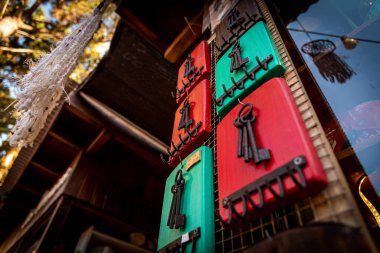 Renkli ahşap bir anahtarlıkta asılı paslı anahtarlar.