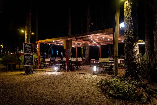 Cena noturna de um elegante bar ao ar livre iluminado por pequenas lâmpadas penduradas — Fotografia de Stock