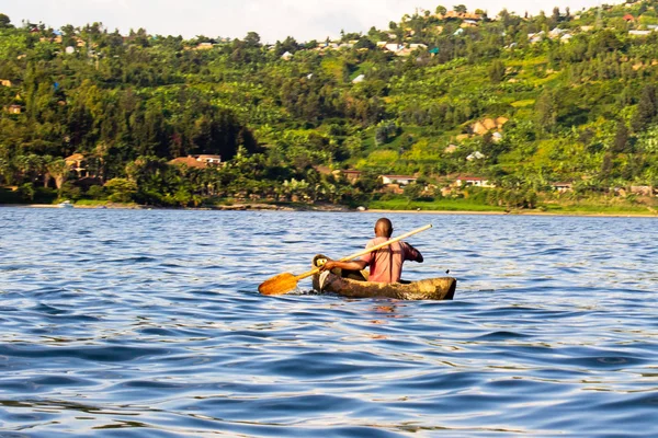 Fisherman Paddling in Dugout Canoe in Lake Kivu, Gisenyi, Rwanda - African man