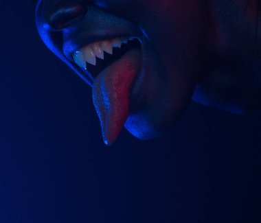 Kadın ağzı keskin dişleri ve kanlı dil ile. Halloween korku gecesi. Güzel seksi genç kadın ile koyu mavi yüz vampir. mistik makyaj. Korkunç bir tanrıça. Öfkeli Lilith.