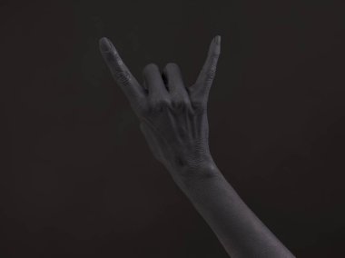 Karanlık bir arka plan üzerinde keçi jest. Kara El rock simge yapıyor. Bir rock konserinde eller yukarı. Müzik yıldızı. Heavy metal kavramı. Siyah metal.