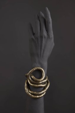 Altın takı ile kadının el Siyah. Oriental bilezik bir siyah el boyalı. Altın takı ve lüks aksesuarları siyah arka plan üzerinde. Yüksek moda sanat kavramı 
