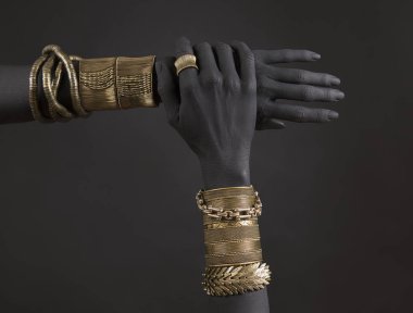 Altın takı ile kadının el Siyah. Oriental bilezik bir siyah el boyalı. Altın takı ve lüks aksesuarları siyah arka plan üzerinde. Yüksek moda sanat kavramı 