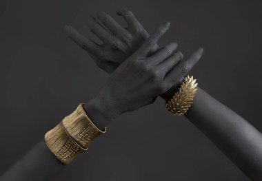 Altın takı ile kadının el Siyah. Oriental bilezik bir siyah el boyalı. Altın takı ve lüks aksesuarları siyah arka plan üzerinde. Yüksek moda sanat kavramı 