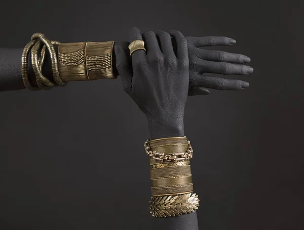 黑人女人的手和黄金首饰 东方手链上的黑色画的手 黄金首饰和豪华配件在黑色背景特写镜头 高级时尚艺术理念 免版税图库图片