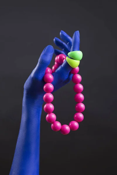 Trendiger Plastikschmuck. blaue Frauenhand mit massivem Plastik-B — Stockfoto