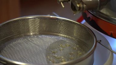 Sıvı taze kavrulmuş bal tüpten eleğe akar.