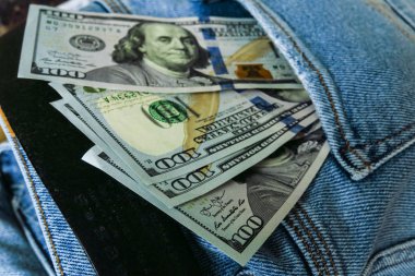 ABD doları cebinde görünür. 100 dolar faturaları kot kot cepli dışarı yapışıyor.