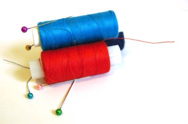 Beyaz arka plan üzerinde renkli iplik bobinleri, dikiş,