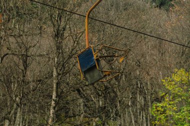 Chairlift on the Caucasus Mountains. Old unworking chairlift in the forest. clipart