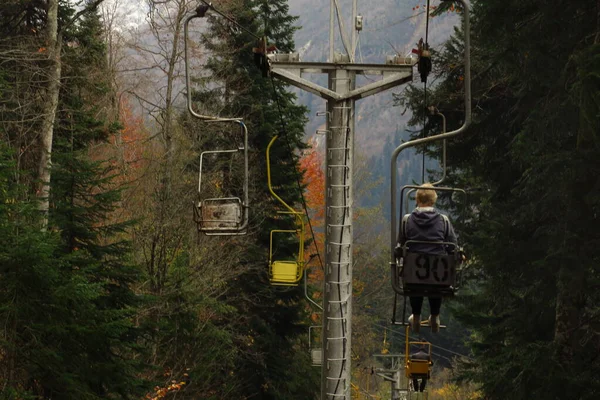 Stary wyciąg krzesełkowy biegnie przez las. Kaukaskie góry. — Zdjęcie stockowe