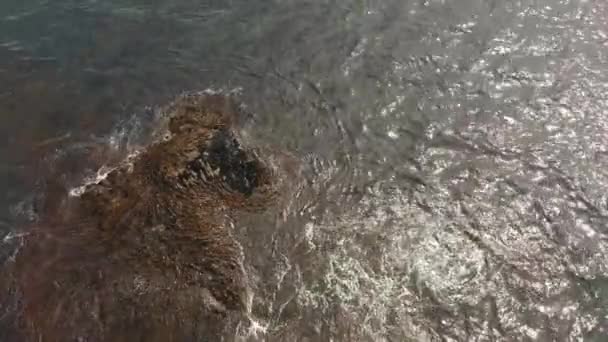 Luftaufnahme von oben, wie riesige Meereswellen krachen und schäumen. Wellen des Pazifischen Ozeans zerquetschen den Stein. Halbinsel Kamtschatka — Stockvideo