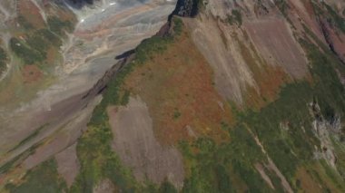 Zirveleri, otlakları, renkli ormanları, Kamçatka yarımadası ve 4k görüntüleriyle sonbahar dağının üzerinden insansız hava aracı uçuşu.