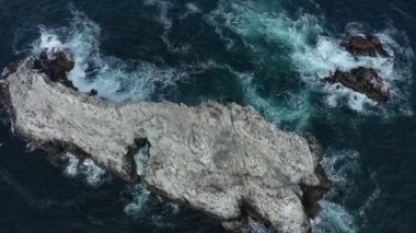 Okyanustaki sığ kayalıklara çarpan dalgaların havası, insansız hava aracıyla kuşbakışı hipnotik desenler yaratıyor. 4k görüntü