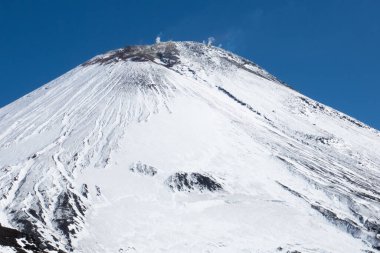 Kış volkanı Avachinskaya Sopka - Kamçatka Yarımadası 'nın aktif dağı, Avacha Volkanı' nın volkanik aktivitesi: gökyüzündeki kraterden püsküren buhar, gaz. Dramatik bulutlar karamsar siyah beyaz görüntü