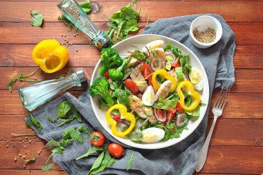 Avokado ve kiraz domates, roka ve pancar tavuk salatası bırakır. Ahşap arka plan üzerinde tavuk ve sebze ile sağlıklı öğle yemeği kase. Sağlıklı gıda kavramı