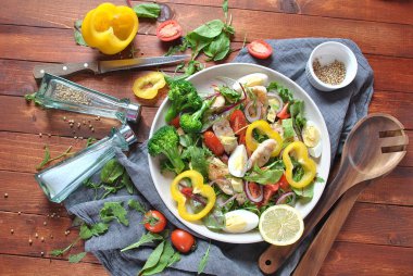 Avokado ve kiraz domates, roka ve pancar tavuk salatası bırakır. Ahşap arka plan üzerinde tavuk ve sebze ile sağlıklı öğle yemeği kase. Sağlıklı gıda kavramı