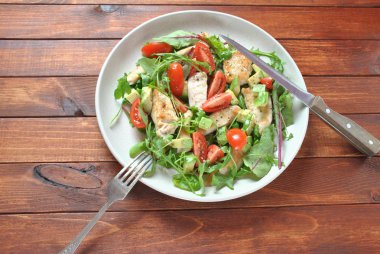 Avokado ve kiraz domates, roka ve pancar tavuk salatası bırakır. Ahşap arka plan üzerinde tavuk ve sebze ile sağlıklı öğle yemeği kase. Sağlıklı gıda kavramı