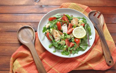 Avokado ve kiraz domates, roka ve pancar tavuk salatası bırakır. Ahşap arka plan üzerinde tavuk ve sebze ile sağlıklı öğle yemeği kase. Sağlıklı gıda kavramı