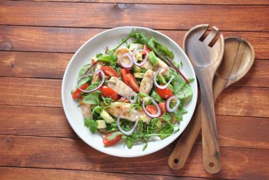 Avokado ve kiraz domates, roka ve pancar tavuk salatası bırakır. Ahşap arka plan üzerinde tavuk ve sebze ile sağlıklı öğle yemeği kase. Sağlıklı gıda kavramı