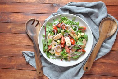 Avokado ve kiraz domates, roka ve pancar tavuk salatası bırakır. Ahşap arka plan üzerinde tavuk ve sebze ile sağlıklı öğle yemeği kase. Sağlıklı gıda kavramı