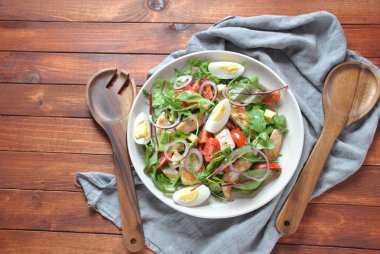 Avokado ve kiraz domates, roka ve pancar tavuk salatası bırakır. Ahşap arka plan üzerinde tavuk ve sebze ile sağlıklı öğle yemeği kase. Sağlıklı gıda kavramı