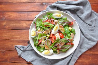 Avokado ve kiraz domates, roka ve pancar tavuk salatası bırakır. Ahşap arka plan üzerinde tavuk ve sebze ile sağlıklı öğle yemeği kase. Sağlıklı gıda kavramı