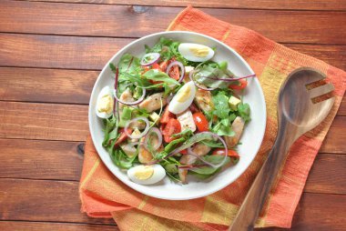 Avokado ve kiraz domates, roka ve pancar tavuk salatası bırakır. Ahşap arka plan üzerinde tavuk ve sebze ile sağlıklı öğle yemeği kase. Sağlıklı gıda kavramı