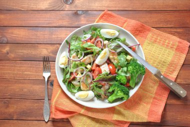 Avokado ve kiraz domates, roka ve pancar tavuk salatası bırakır. Ahşap arka plan üzerinde tavuk ve sebze ile sağlıklı öğle yemeği kase. Sağlıklı gıda kavramı