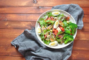 Avokado ve kiraz domates, roka ve pancar tavuk salatası bırakır. Ahşap arka plan üzerinde tavuk ve sebze ile sağlıklı öğle yemeği kase. Sağlıklı gıda kavramı