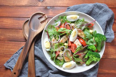 Avokado ve kiraz domates, roka ve pancar tavuk salatası bırakır. Ahşap arka plan üzerinde tavuk ve sebze ile sağlıklı öğle yemeği kase. Sağlıklı gıda kavramı