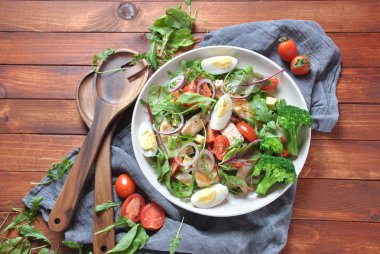 Avokado ve kiraz domates, roka ve pancar tavuk salatası bırakır. Ahşap arka plan üzerinde tavuk ve sebze ile sağlıklı öğle yemeği kase. Sağlıklı gıda kavramı