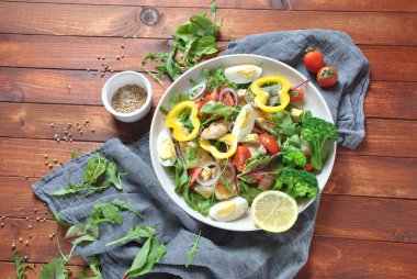 Avokado ve kiraz domates, roka ve pancar tavuk salatası bırakır. Ahşap arka plan üzerinde tavuk ve sebze ile sağlıklı öğle yemeği kase. Sağlıklı gıda kavramı