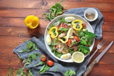 Avokado ve kiraz domates, roka ve pancar tavuk salatası bırakır. Ahşap arka plan üzerinde tavuk ve sebze ile sağlıklı öğle yemeği kase. Sağlıklı gıda kavramı