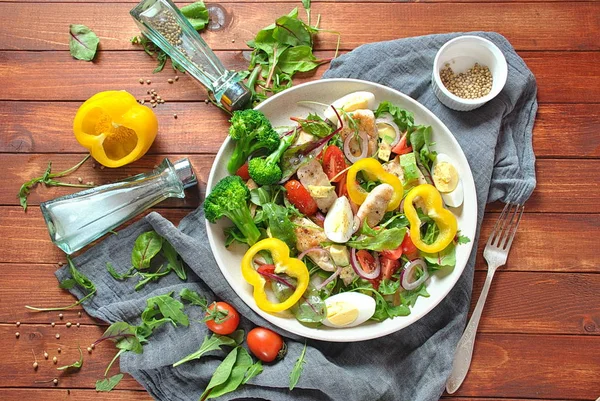 Avokado ve kiraz domates, roka ve pancar tavuk salatası bırakır. Ahşap arka plan üzerinde tavuk ve sebze ile sağlıklı öğle yemeği kase. Sağlıklı gıda kavramı