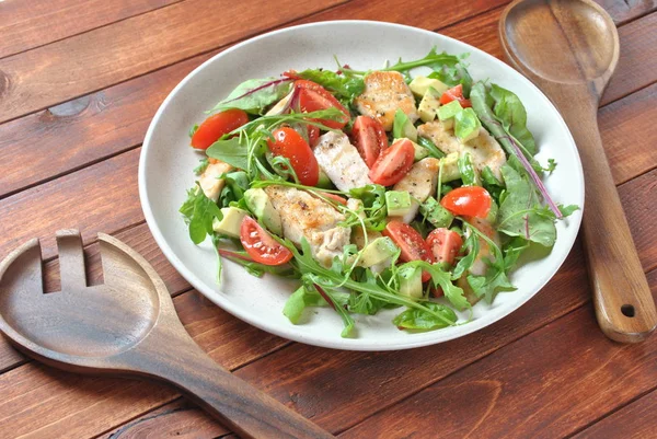 Avokado ve kiraz domates, roka ve pancar tavuk salatası bırakır. Ahşap arka plan üzerinde tavuk ve sebze ile sağlıklı öğle yemeği kase. Sağlıklı gıda kavramı