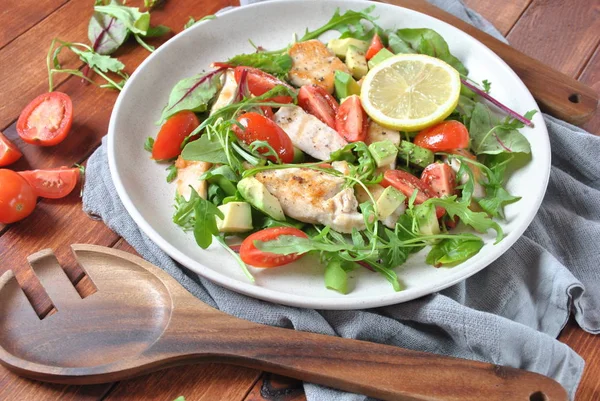 Avokado ve kiraz domates, roka ve pancar tavuk salatası bırakır. Ahşap arka plan üzerinde tavuk ve sebze ile sağlıklı öğle yemeği kase. Sağlıklı gıda kavramı